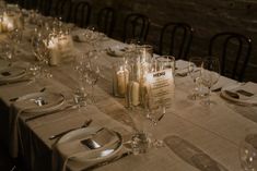 a long table is set with candles and place settings for the dinner guests to enjoy