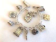 "Adorable quilting charm bracelet featuring detailed 3D pewter quilting charms and personalized initial and Swarovski birthstone on silver bracelet with toggle clasp. Ten beautifully detailed quilting charms are all 3D/two-sided pewter made in USA and lead and nickel free. Included are: thimble with heart, friendship star quilting block, Singer sewing machine, scissors, \"I Love Quilting\" block, spool of thread with needle, Dresden flower block, pin cushion, tape measure, and iron. Hand stamped Personalized Silver Charm Bracelet For Gift Making, Personalized Silver Jewelry With Dangling Charms, Silver Jewelry With Dangling Charms For Personalized Gift, Vintage Silver Jewelry For Gift Making, Silver Bracelet Jewelry For Gift Making, Spool Of Thread, Quilter Gifts, Iron Hand, Personalized Quilt