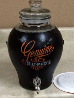 a large black beverage dispenser sitting on top of a counter next to a plate