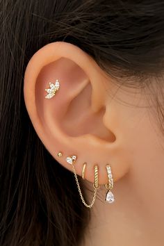 a woman's ear with three different types of piercings