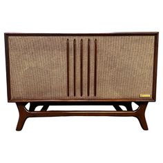 an old fashioned radio with wicker on it's sides and wooden legs, against a white background