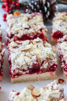 raspberry bars with almonds and crumbled toppings on a white surface