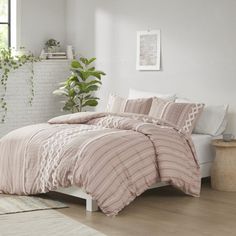 a bed in a bedroom with pink comforter and pillows