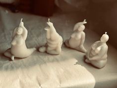 four small white figurines sitting on top of a table next to each other