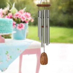 a wind chime hanging from the side of a table next to a flower pot