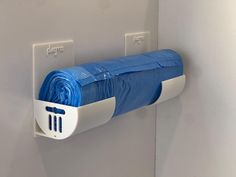 a toilet paper dispenser mounted to the wall with blue cloth on it