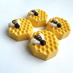 four pieces of wax that have been made to look like honeycombs with bees on them