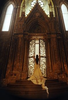 a woman standing in front of an ornate doorway