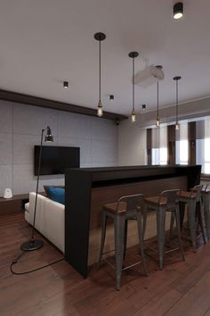 a room that has some stools and a bar in the middle with lights hanging above it