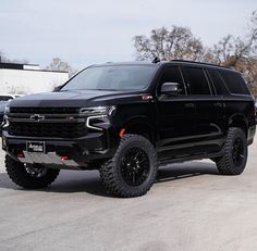 a large black truck parked in a parking lot