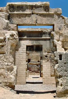 the entrance to an ancient building with stone walls and doorways, in front of a blue sky