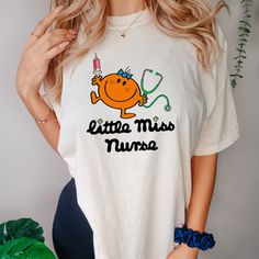 a woman wearing a t - shirt that says little miss nurse