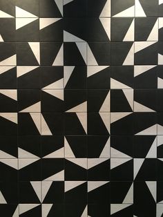 a black and white tiled wall with lots of arrows