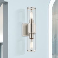 a wall light that is mounted on the side of a wall with a glass cylinder