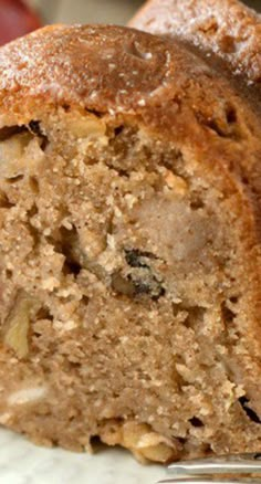 a close up of a piece of bread on a plate with apples in the background