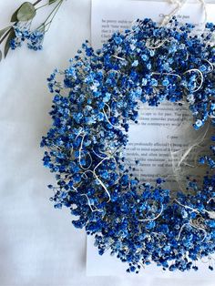 blue flowers are arranged on top of an open book