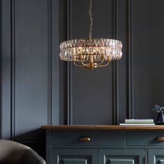 a chandelier hanging from the ceiling in a room with dark walls and furniture