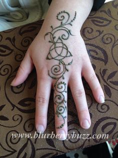 a person's hand with a tattoo on it and a ring around the wrist