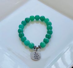 Green Aventurine is known to be an exceptional stone for manifesting luck, prosperity, success, and good health in abundance. It is also great for balancing emotions related to relationships; often ones later in life. This bracelet is lightly accented with a leaf-stamped charm that symbolizes continuous growth through whatever phase you are presently in. Spiritual Jade Stretch Bracelet For Meditation, Jade Stretch Bracelet With Natural Stones For Meditation, Jade Stretch Bracelet For Meditation With Natural Stones, Green Aventurine Stretch Bracelet With Natural Stones, Adjustable Aventurine Stretch Bracelet Gift, Green Aventurine Stretch Bracelet Gift, Adjustable Aventurine Spiritual Stretch Bracelet, Aventurine Round Beads Stretch Bracelet As Gift, Aventurine Stretch Bracelet With Round Beads As Gift