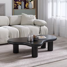 a living room with a white couch and black coffee table