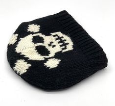 a knitted skull and crossbone hat on a white background