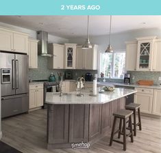 a kitchen with an island in the middle and two stools at the counter top