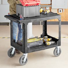 a man standing next to a work cart with tools on it and an open tool box