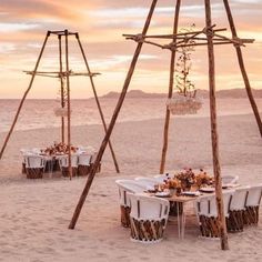 an outdoor dining set up on the beach with white tablecloths and chairs around it