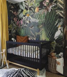 a baby's room decorated with tropical wallpaper and animal print, including a crib