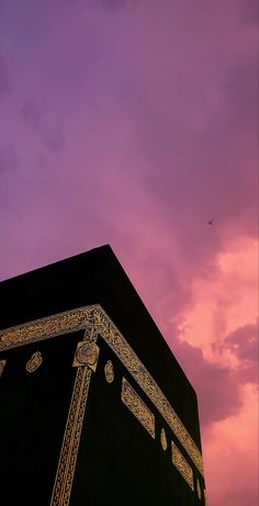 the top of a building under a purple sky with clouds in the backgroud