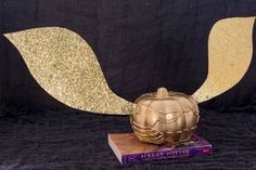 a golden pumpkin sitting on top of a book