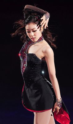 a woman in a short black dress walking down a runway