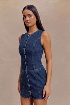 Denim devotion. The JANE Button Down Denim Mini Dress is a stylish and versatile addition to any wardrobe. Featuring a round neckline and a centre front button closure, this sleeveless dress offers a clean and classic look. The front mock pockets and princess seams add subtle detailing, enhancing the dress's tailored fit. With its mini length, the Jane dress is perfect for both casual outings and dressier occasions, combining the timeless appeal of denim with modern design. Denim Blue Sleeveless Dress With Buttons, Sleeveless Denim Mini Dress With Button Closure, Sleeveless Denim Blue Dress With Buttons, Chic Sleeveless Denim Dress With Button Closure, Fitted Sleeveless Denim Dress With Buttons, Fitted Sleeveless Denim Dress With Button Closure, Medium Wash Sleeveless Mini Dress With Button Closure, Sleeveless Medium Wash Mini Dress With Button Closure, Sleeveless Denim Mini Dress With Buttons