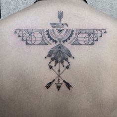 the back of a woman's upper body with an arrow and arrows tattoo