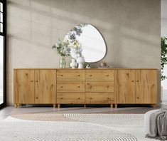 a room with a dresser, mirror and rug on the floor in front of it