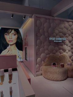 a room with several items on display in front of a large screen that says kylie cosmetics