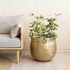 a gold planter sitting next to a chair