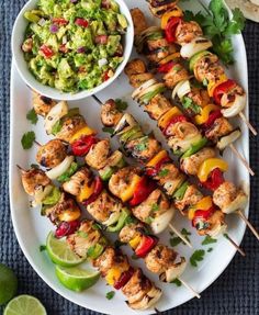 chicken kabobs on skewers with guacamole and salsa