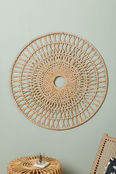 a rattan chair and wicker table in front of a green wall with a circular cutout on the wall