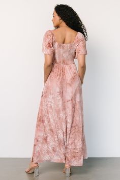 a woman in a pink dress looking off to the side