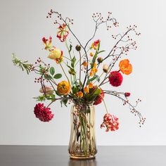 a vase filled with lots of different colored flowers