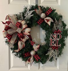 a christmas wreath with the word no elf on it and ornaments hanging from it's front door