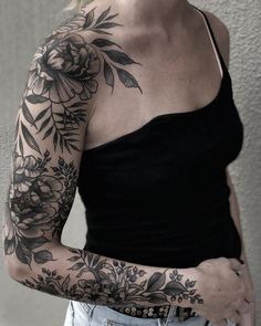 a woman with a flower tattoo on her arm and shoulder is posing for the camera