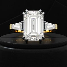 an emerald cut diamond ring with three baguets