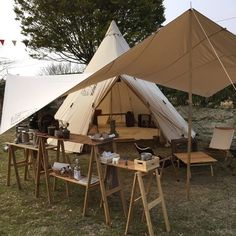 an outdoor tent with chairs and tables under it