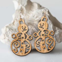 wooden earrings with an image of a cat on the front, and a swirl design on the back