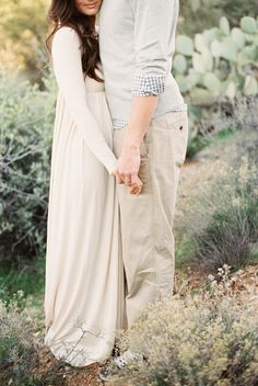 a man and woman holding hands in the desert