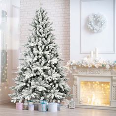 a white christmas tree in front of a fireplace