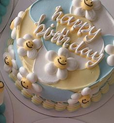 a birthday cake decorated with smiley faces and the words happy birthday