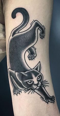 a black and white cat tattoo on the leg